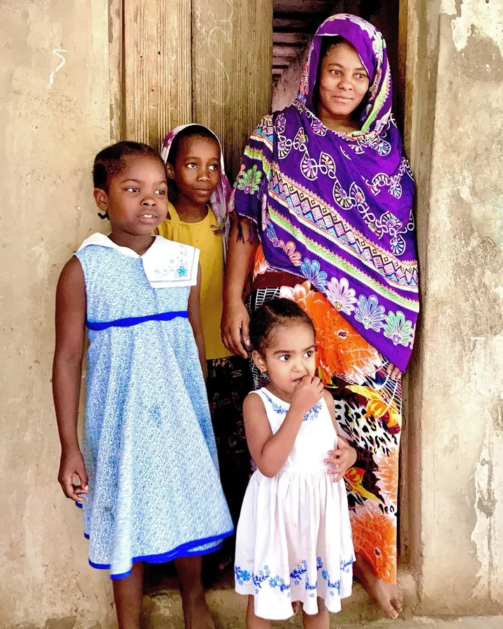 Mama z trojgiem dzieci w drzwiach domu na Zanzibarze